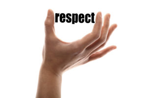 Color horizontal shot of a of a hand squeezing the word "respect".